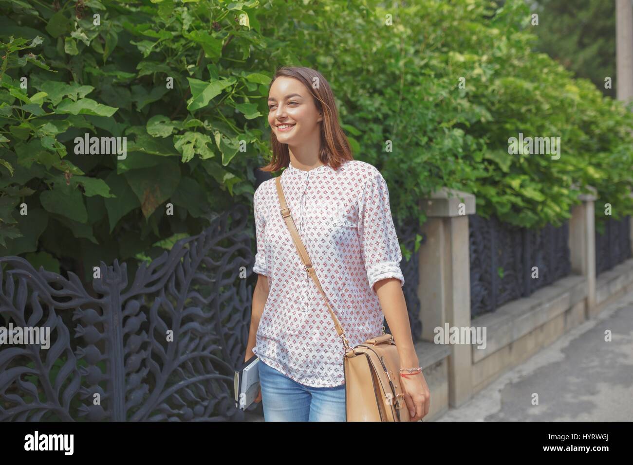 Tanga alla moda ragazza camminare nella città. Gioventù moderna il concetto di stile di vita. Foto Stock