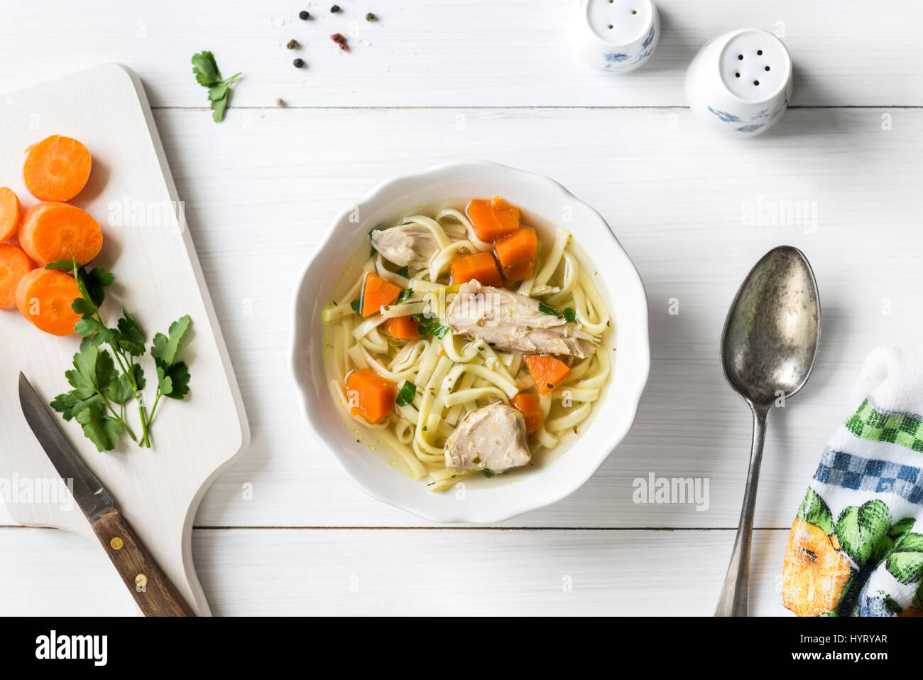 Fresca zuppa di pollo con le verdure e la pasta in una terrina con la carota ed il prezzemolo sul tavolo bianco, vista dall'alto Foto Stock