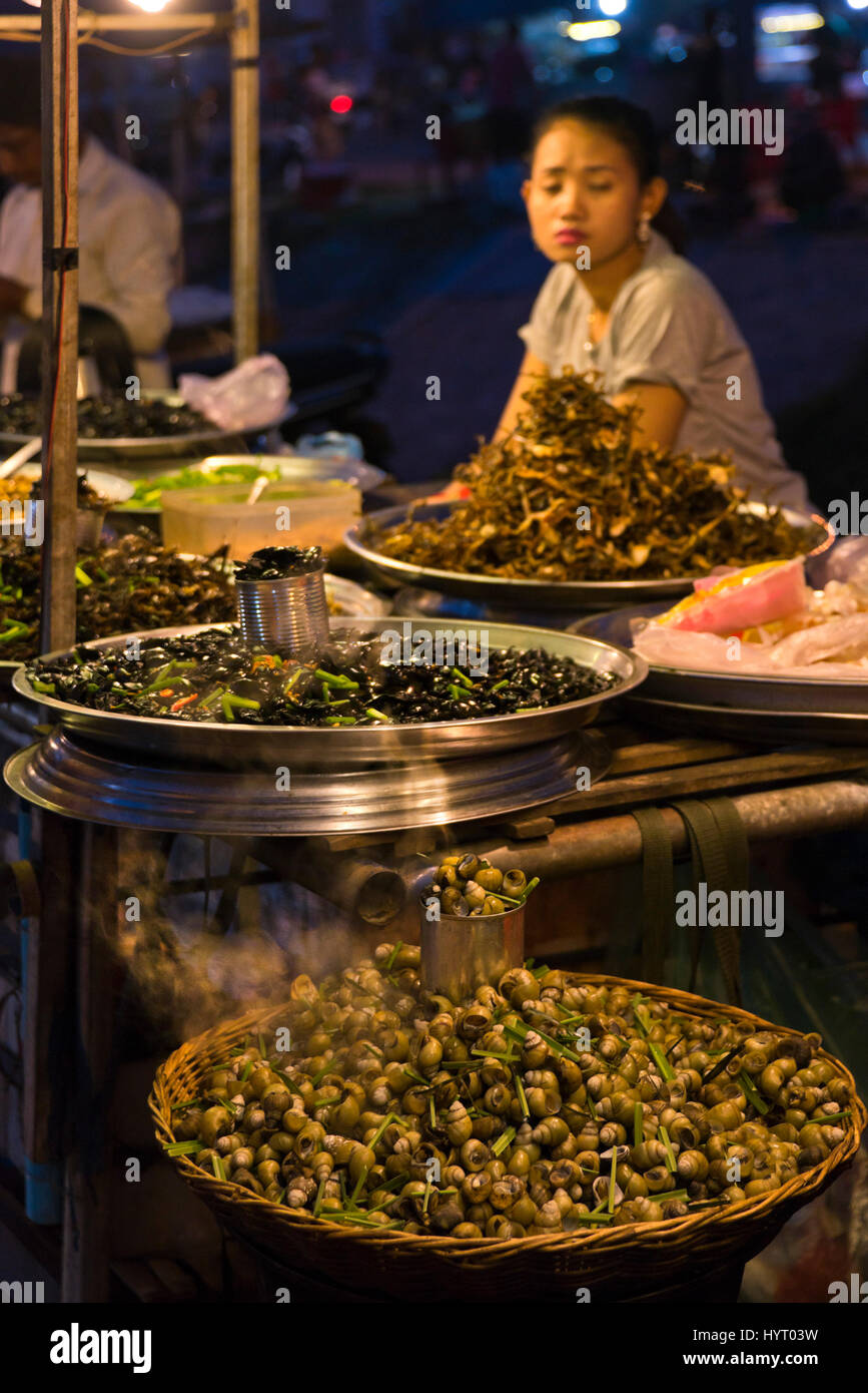 Verticale di vista ravvicinata di lumache, acqua coleotteri, rane e grilli per la vendita in un cibo di strada nel mercato Siem Reap, Cambogia. Foto Stock