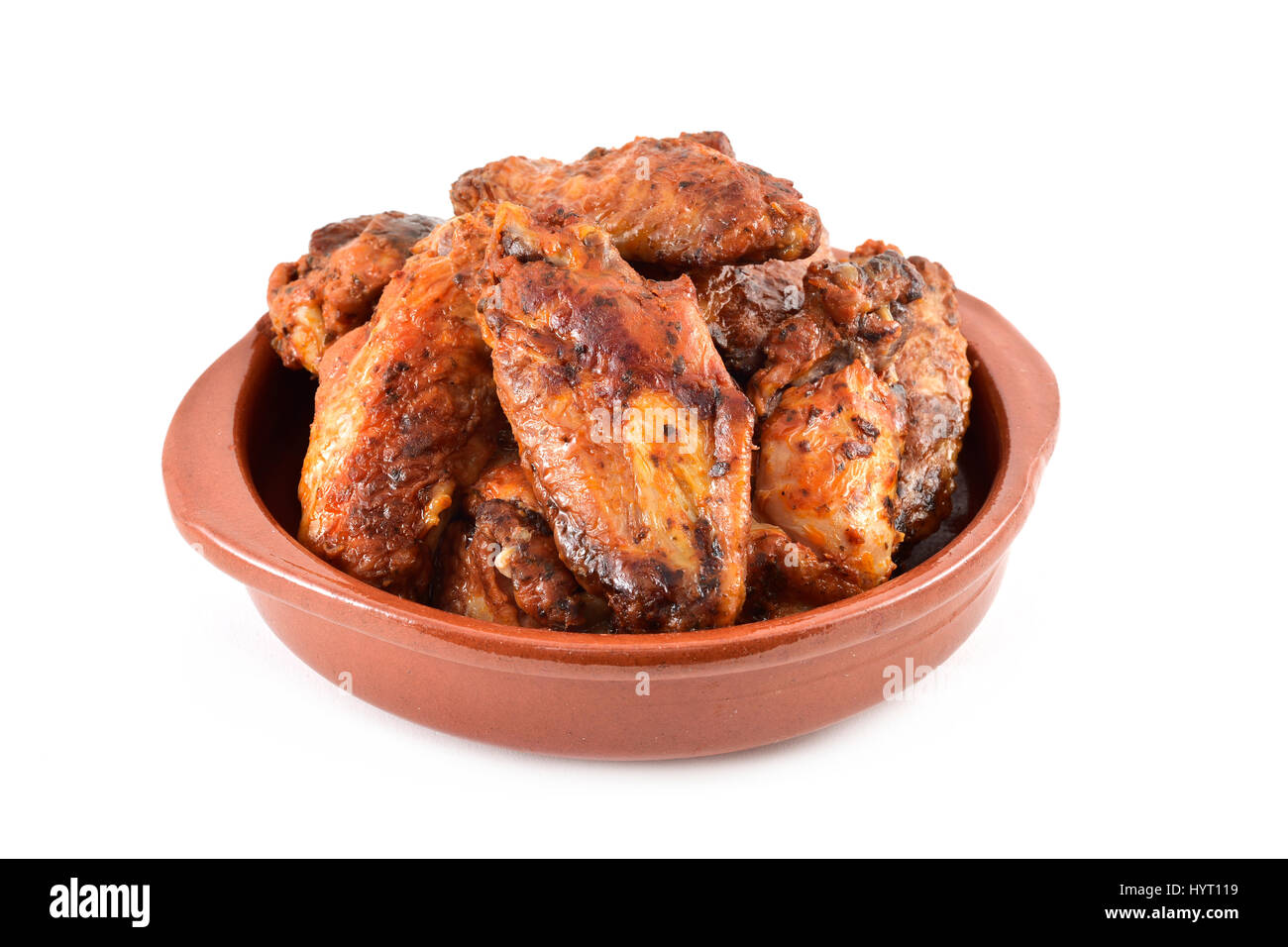 Primo piano di alcuni barbecue ali di pollo in un piatto di terracotta su sfondo bianco Foto Stock