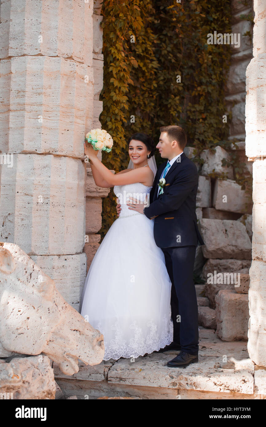 Happy sposi sono in piedi dalla colonna Foto Stock