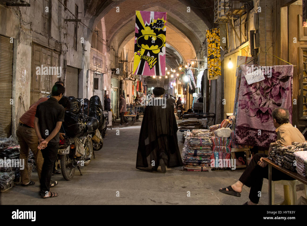 ISFAHAN, IRAN - 20 agosto 2016: Imam passando sotto un Batman logo in Isfahan bazaar la foto di un imam iraniano dal retro camminare sotto un Batman l Foto Stock