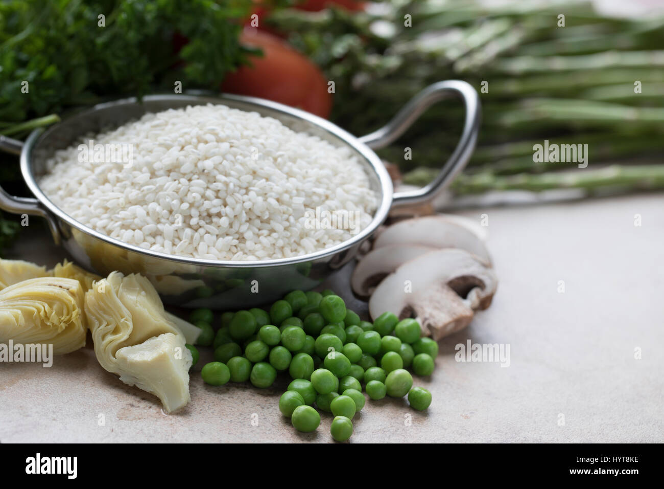 Riso, carciofi, piselli, funghi e altri ingredienti per la paella vegetariana Foto Stock