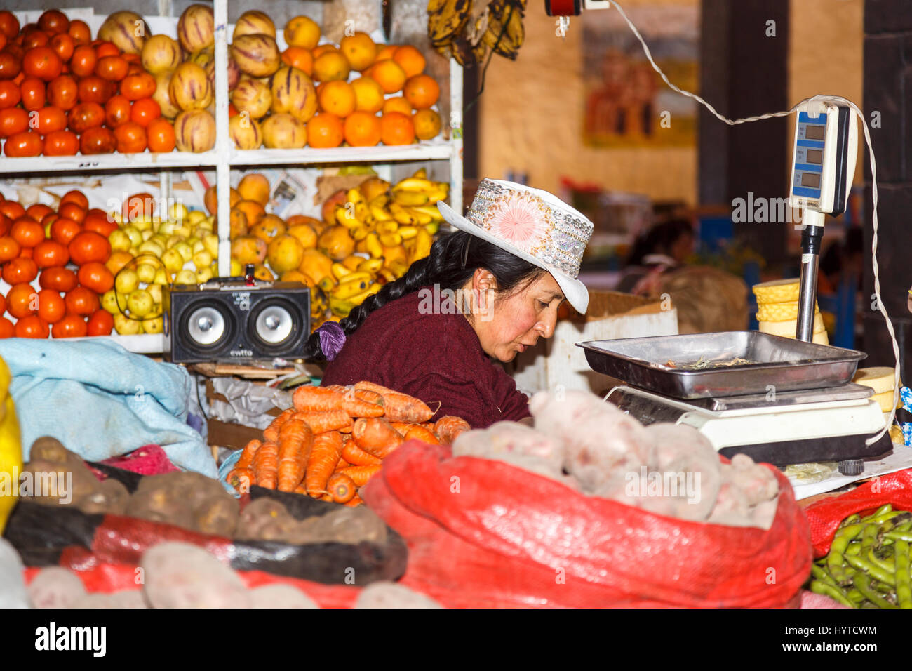 Donna locale stallholder nel tradizionale ricamato rosa hat con rosetta, Chivay, Colca Valley, capitale della provincia di Caylloma, regione di Arequipa, Perù Foto Stock