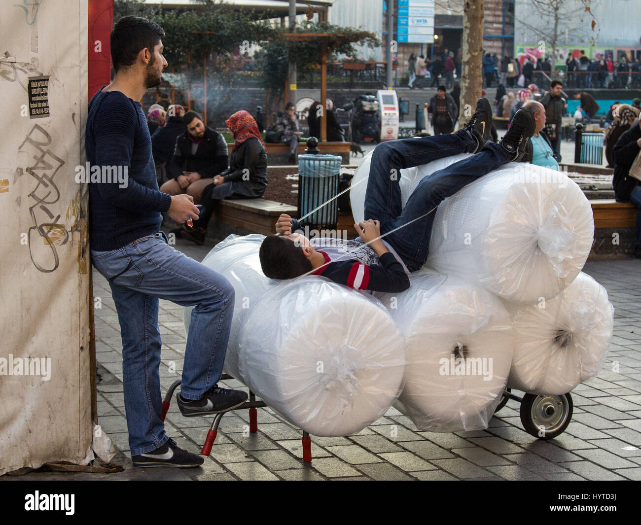 ISTANBUL, Turchia - 28 dicembre 2015: giovani ragazzi di erogazione avente un resto su i loro pacchi nel quartiere Eminonu, sul versante europeo della città due si Foto Stock