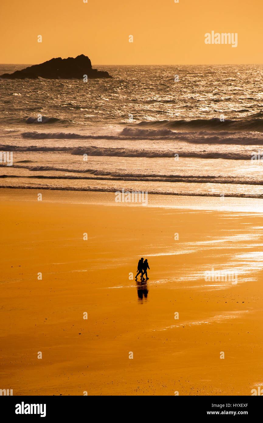 Paio di persone a piedi Silhouette Fistral Beach Sunset serata romantica fine della giornata a riva litorale Newquay Cornwall Foto Stock