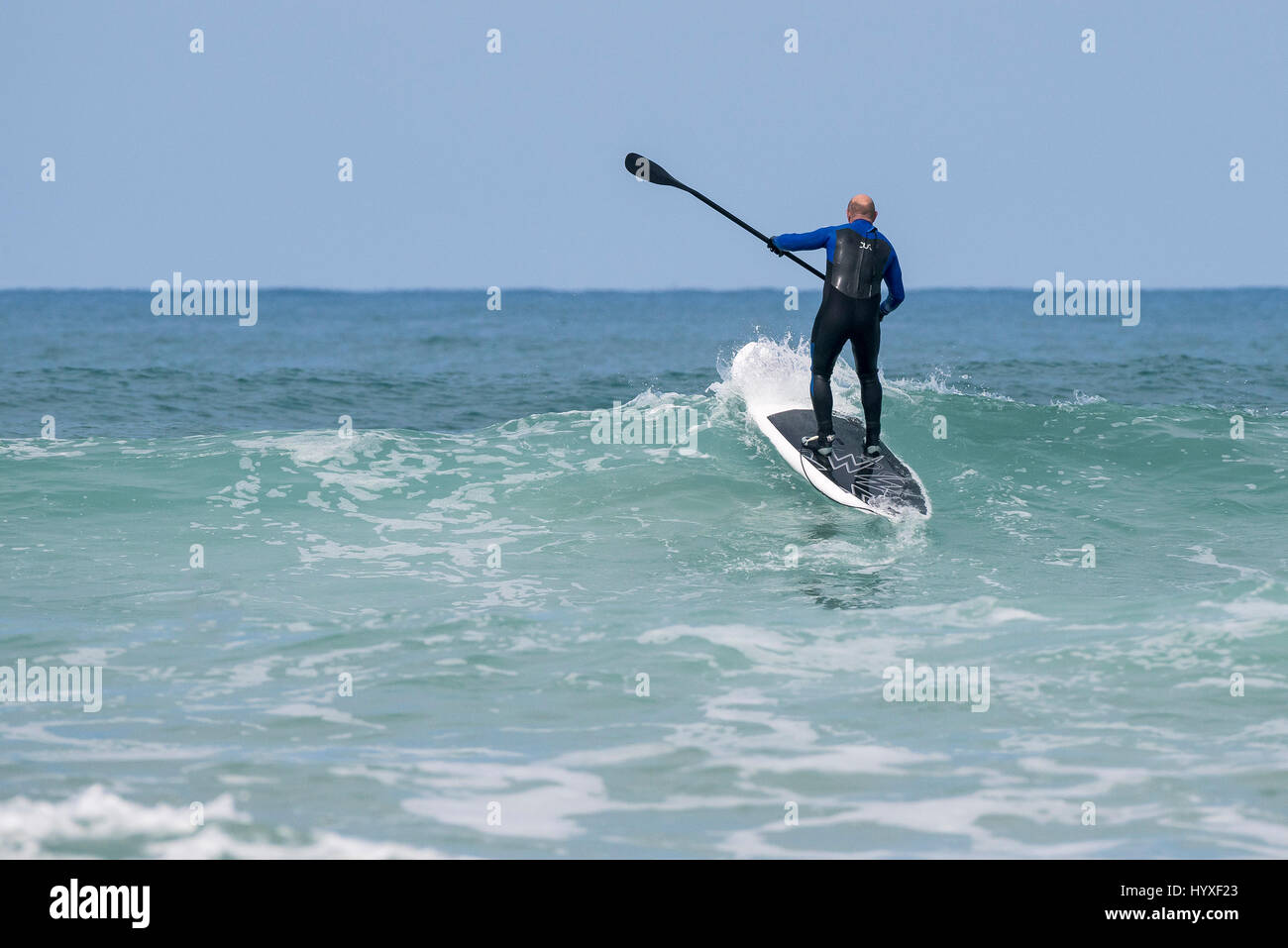 Paddle boarder Paddle boarding Wave Surf board Sea Spray Watersport attività fisica equilibrio di specialità Hobby attività di svago di stile di vita Foto Stock