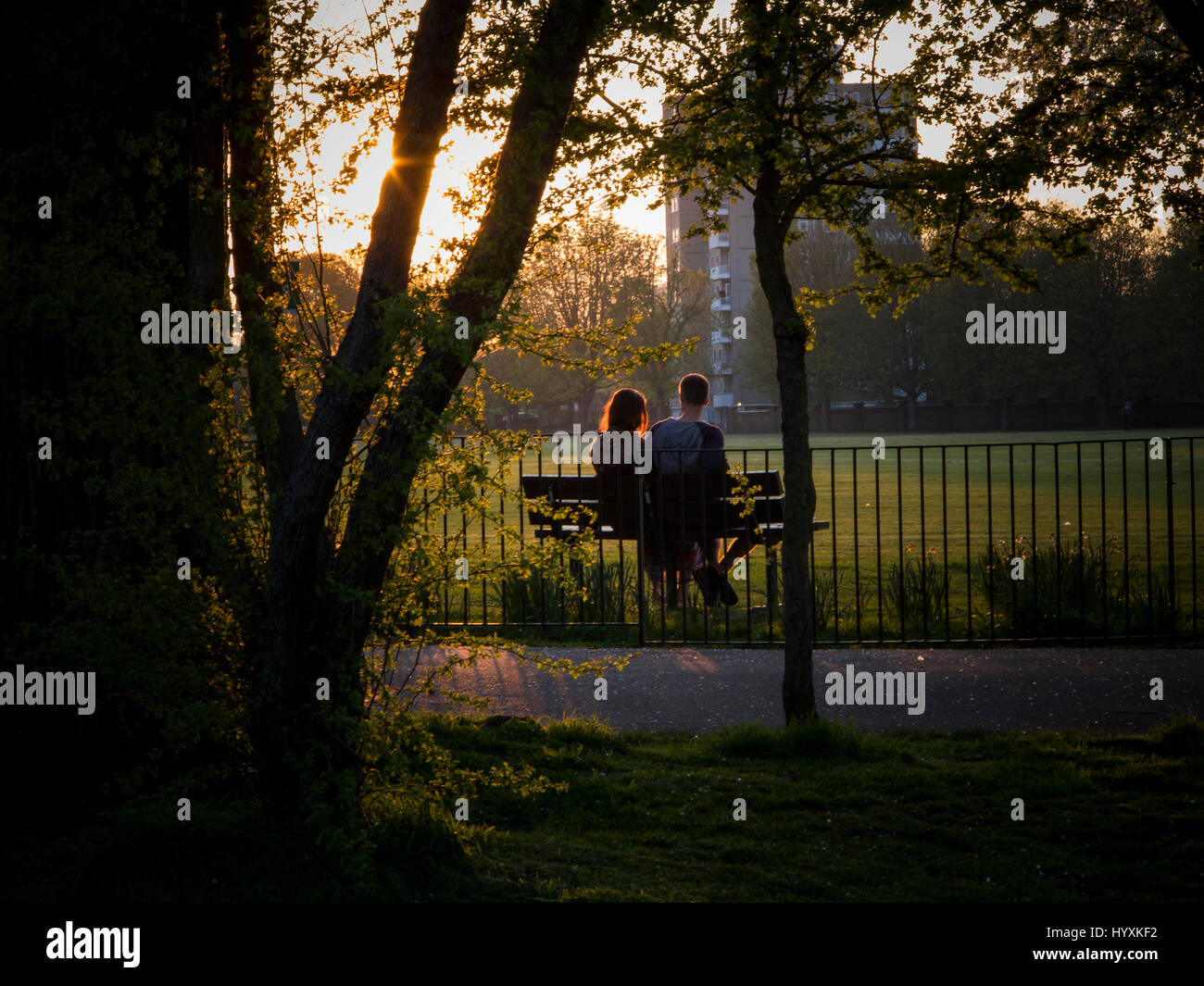 Un giovane seduto su una panchina in un parco a Londra Foto Stock