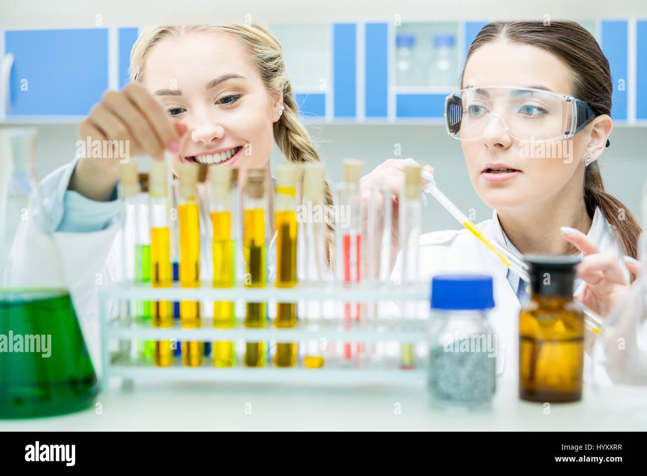 Due donne gli scienziati che lavorano con reagenti in tubi di test in laboratorio Foto Stock