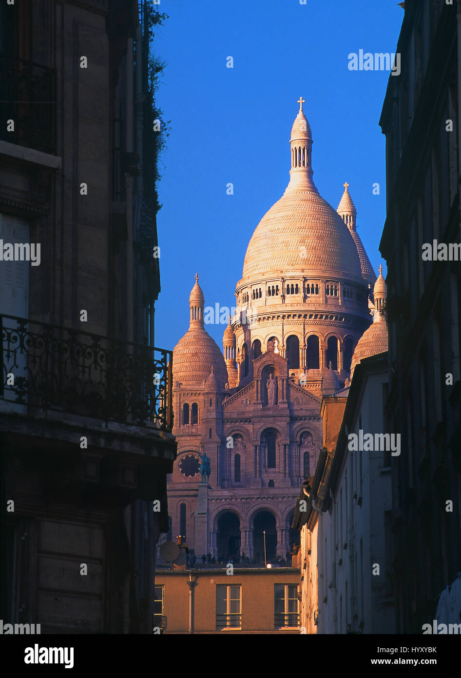 La Basilique du Sacré-Coeur ("Basilica del Sacro Cuore") vista al tramonto da una tipica strada parigina. Montmartre, Parigi, Francia Foto Stock