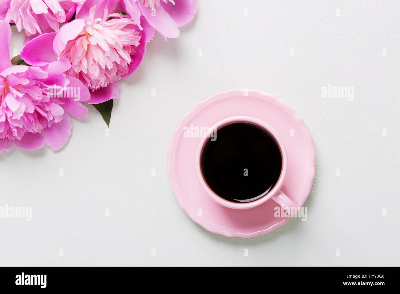 Tazza di caffè e fiori (le peonie) su grigio chiaro tavolo. Foto Stock