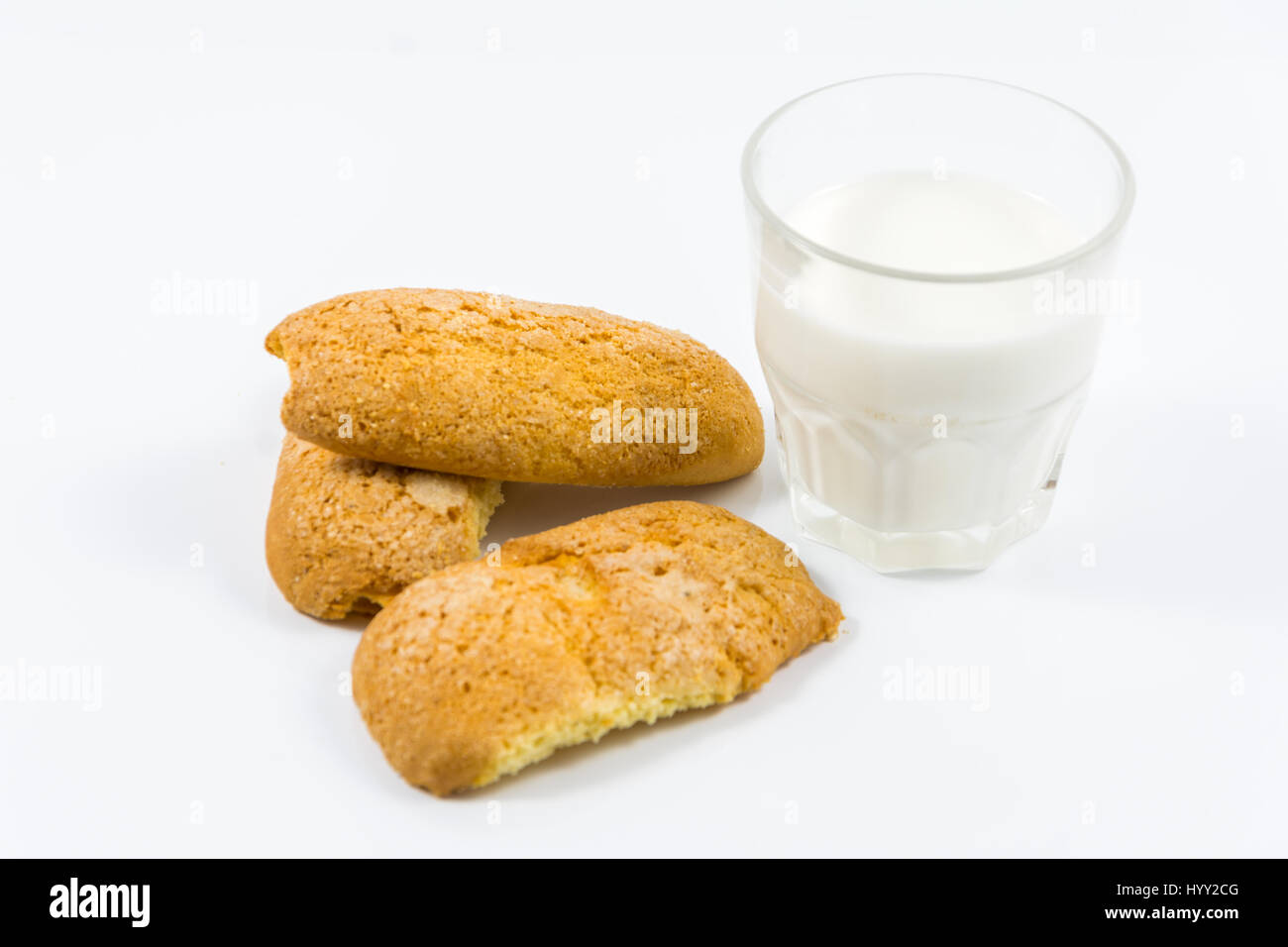 Buiscuits fatti in casa con un bicchiere di latte su sfondo bianco Foto Stock