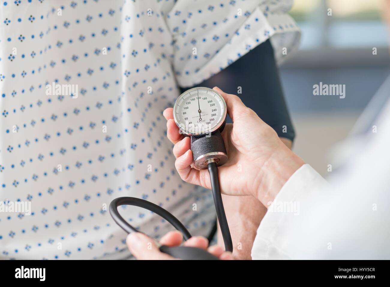 Medico tenendo pressione del sangue del paziente. Foto Stock