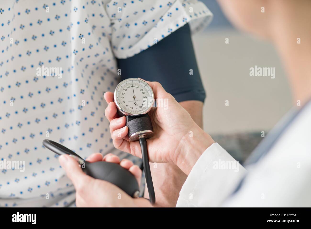 Medico tenendo pressione del sangue del paziente. Foto Stock