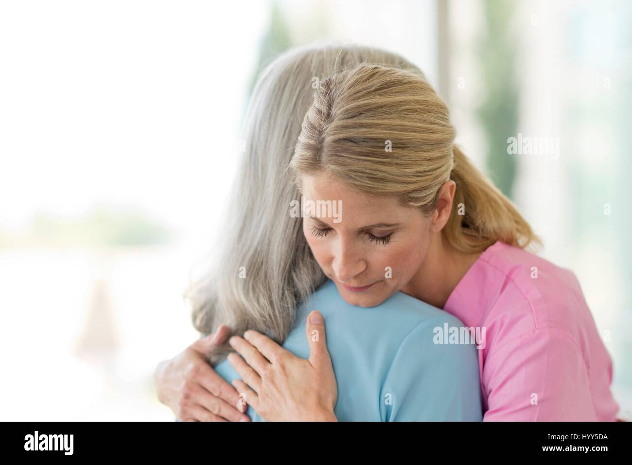 Femmina lavoratore cura abbracciando paziente femmina. Foto Stock