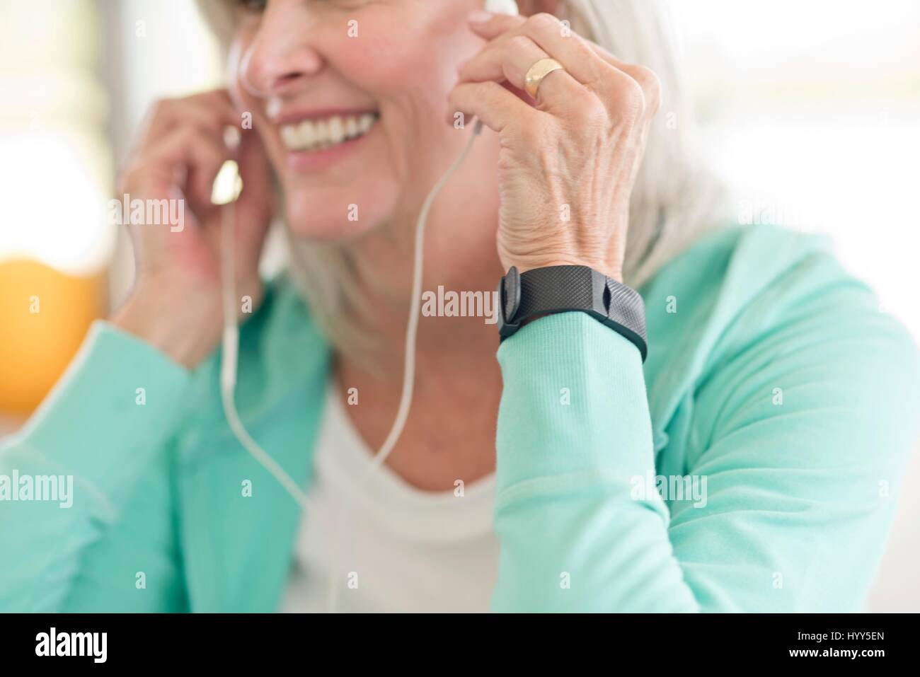 Senior donna l'ascolto di musica in cuffia. Foto Stock