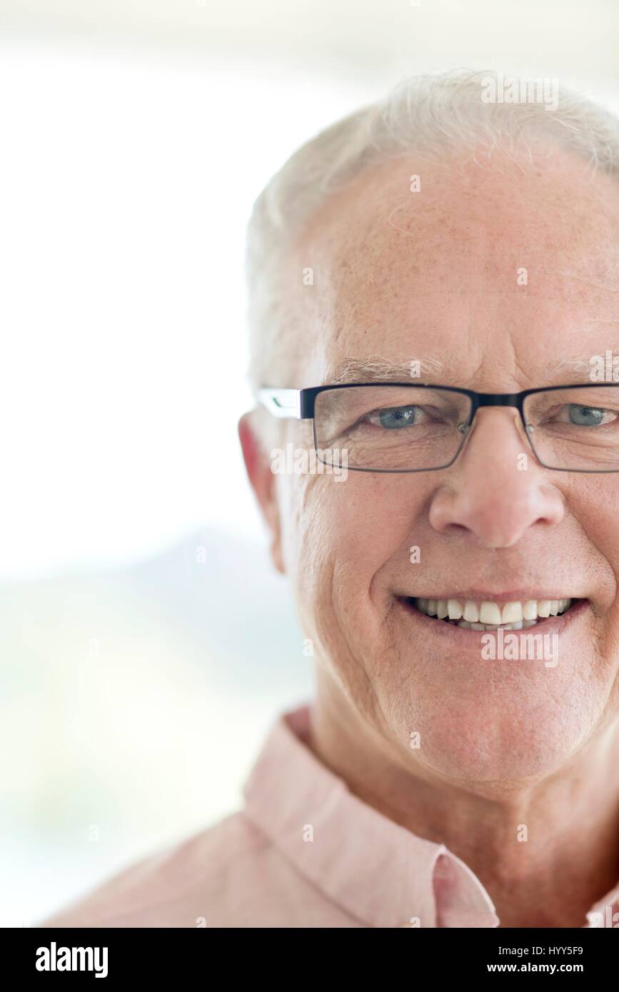 L'uomo anziano con gli occhiali sorridente verso la telecamera. Foto Stock