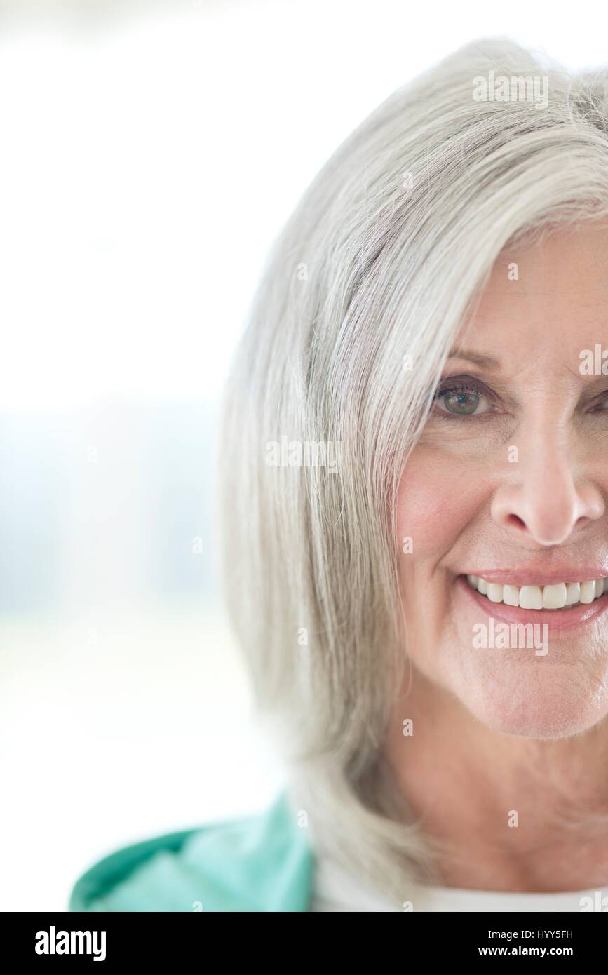 Senior donna sorridente e guardando la fotocamera. Foto Stock