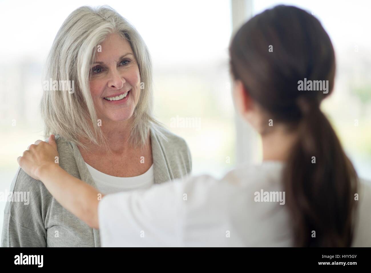 Senior Donna che parla al lavoratore di cura. Foto Stock