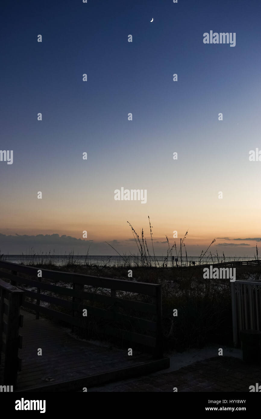 Luna nuova oltre il tramonto di fading glow presso la spiaggia di Pensacola, Florida Foto Stock