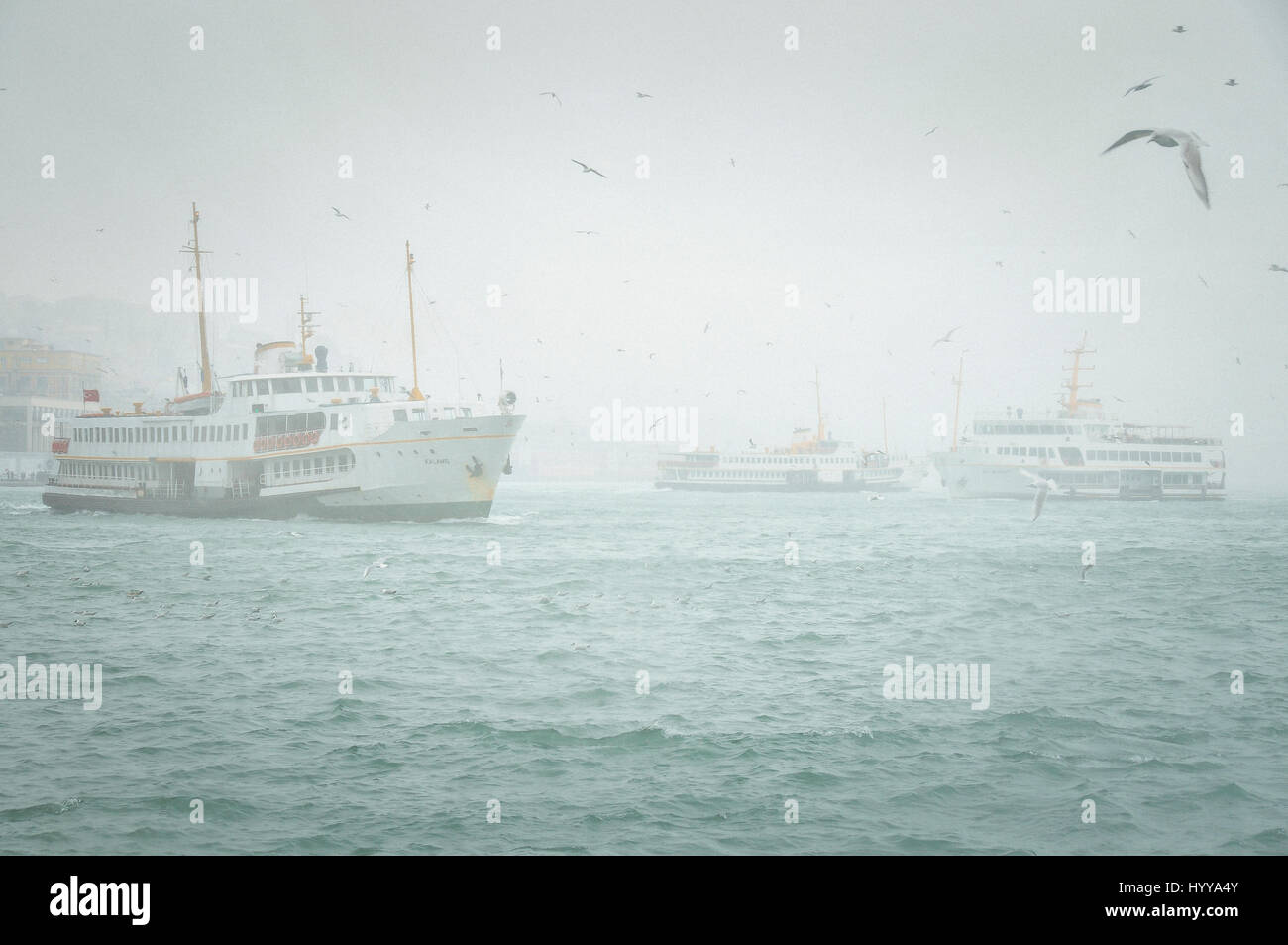I traghetti navigano lungo il Golden Horn in una nebbiosa giornata invernale e in Istanbul Foto Stock