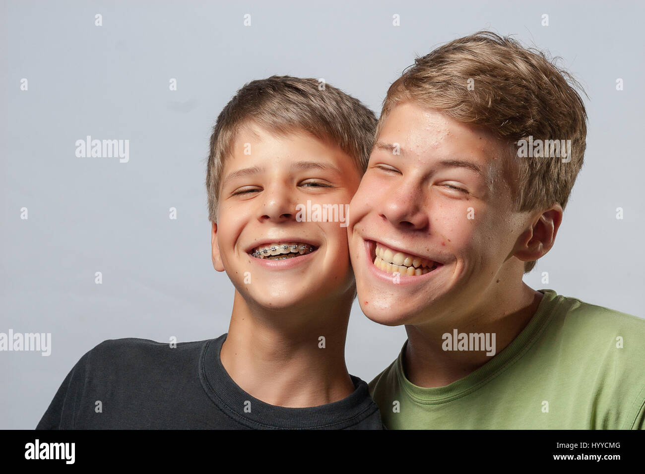 Due ragazzi, guance toccando facendo facce buffe Foto Stock