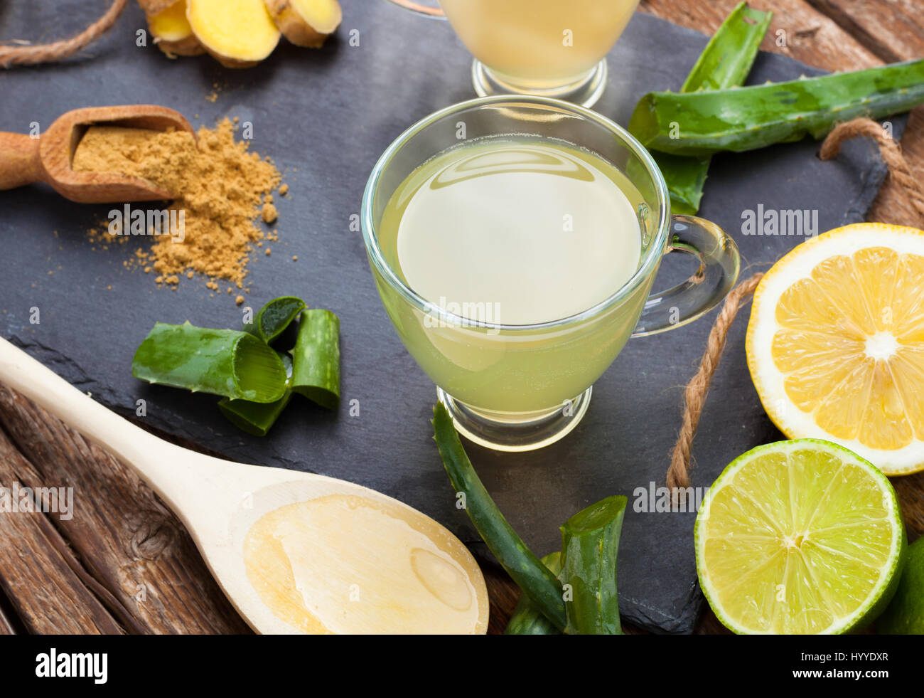 Bere con aloe vera e limoni. Le coppe di vetro su un vassoio di ardesia Foto Stock