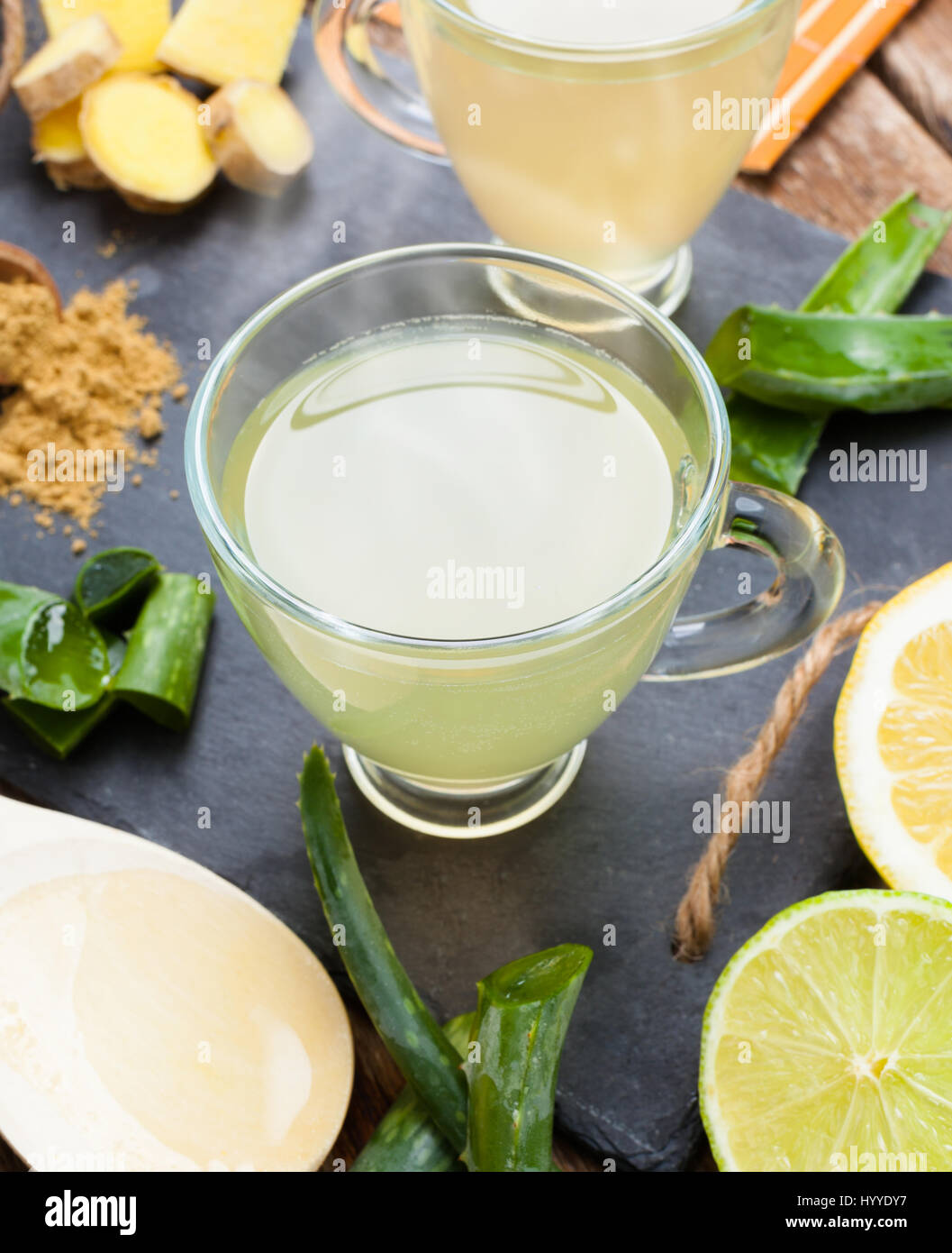 Bere con aloe vera e limoni. Le coppe di vetro su un vassoio di ardesia Foto Stock