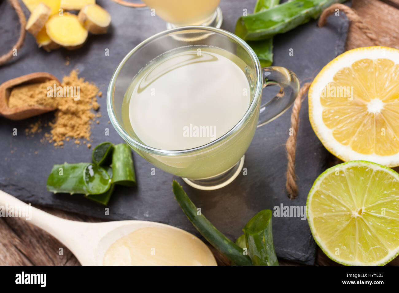 Bere con aloe vera e limoni. Le coppe di vetro su un vassoio di ardesia Foto Stock