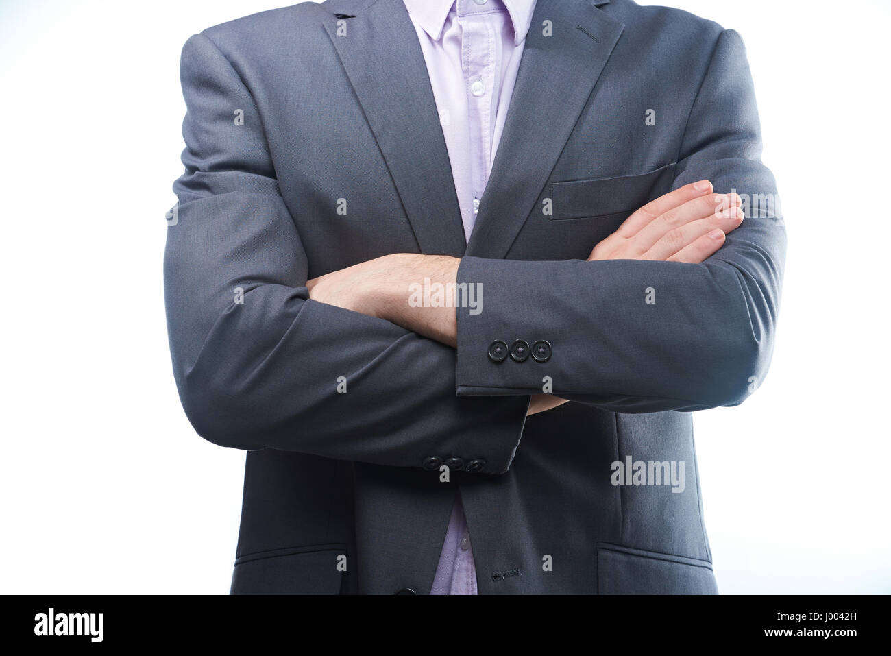 L uomo moderno in tuta con bracci incrociati closeup isolati su sfondo bianco Foto Stock