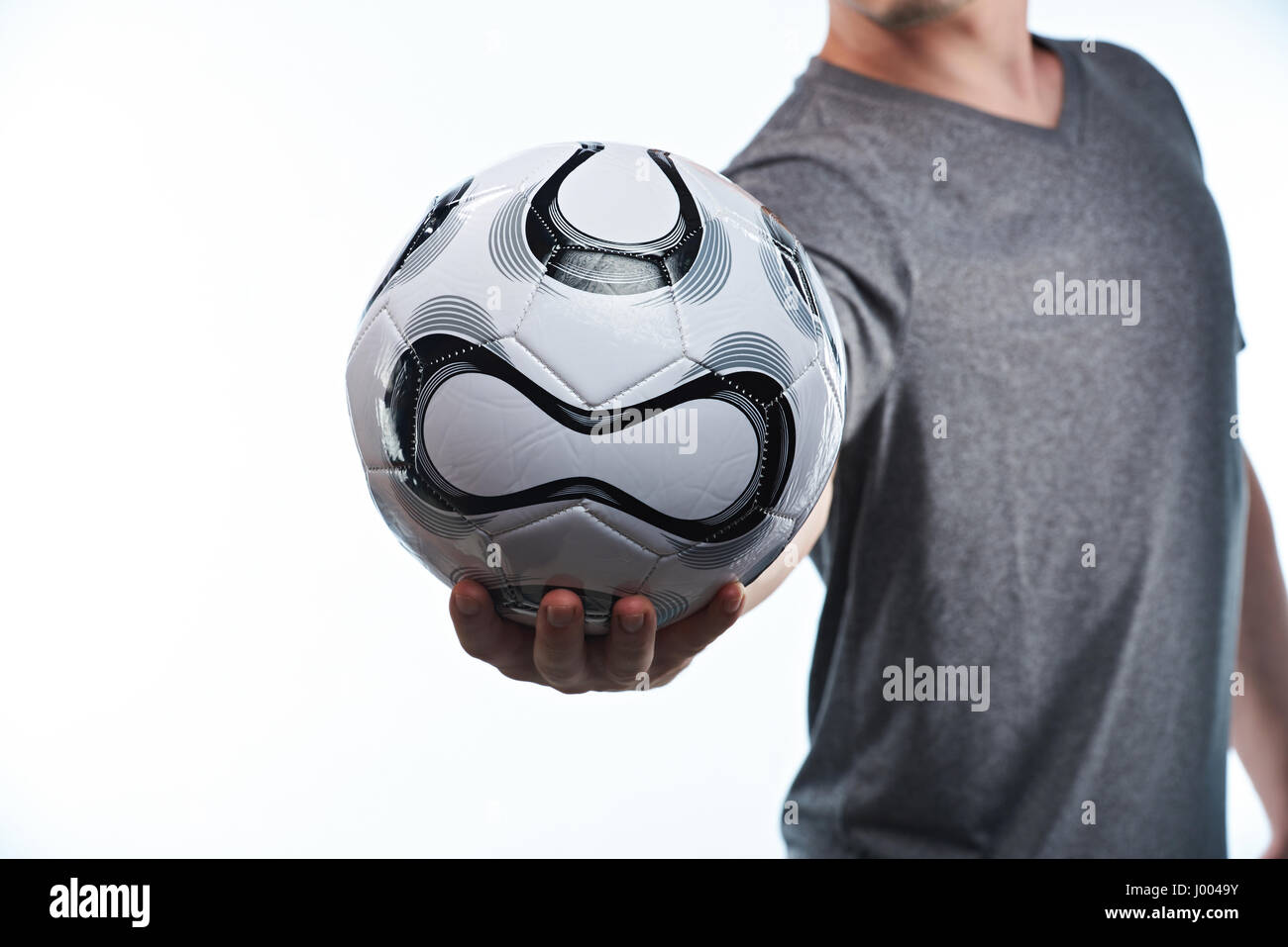 Il calcio palla in mano giocatore closeup isolati su sfondo bianco Foto Stock