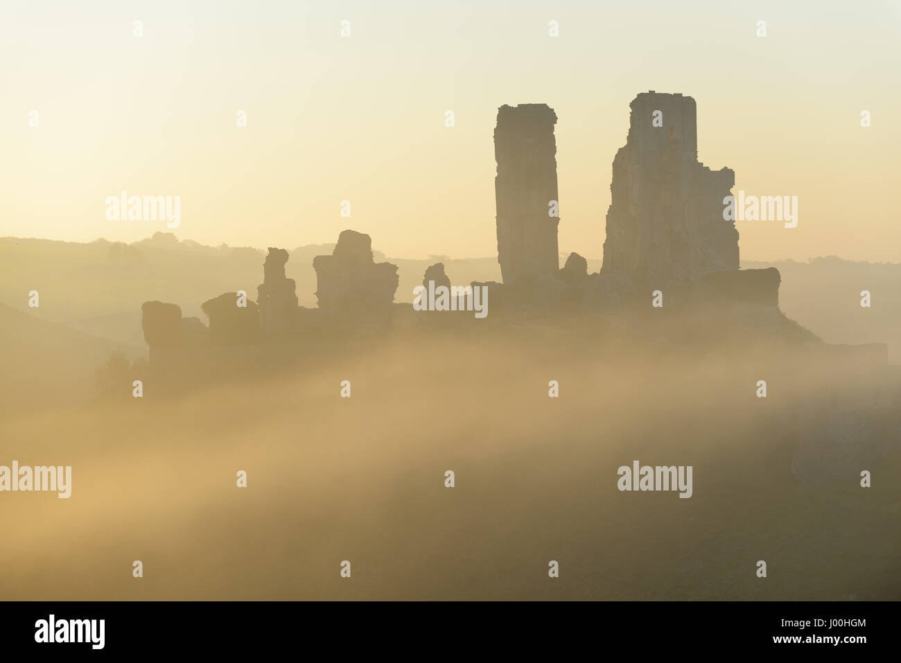 Corfe Castle, Dorset, Regno Unito. Dal 8 aprile 2017. Gloriosa misty crisp tramonto sull'Isola di Purbeck e l'iconica, storiche rovine di Corfe Castle. © DTNews/Alamy Live Foto Stock