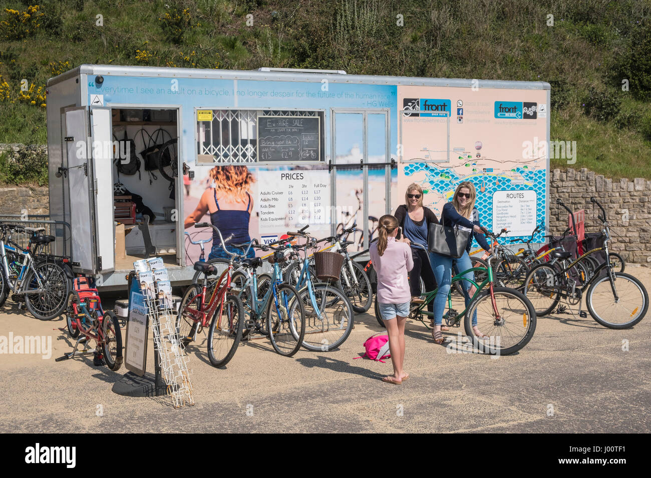 Persone affitto cicli da un negozio di noleggio sul lungomare di Bournemouth Dorset, Regno Unito Foto Stock