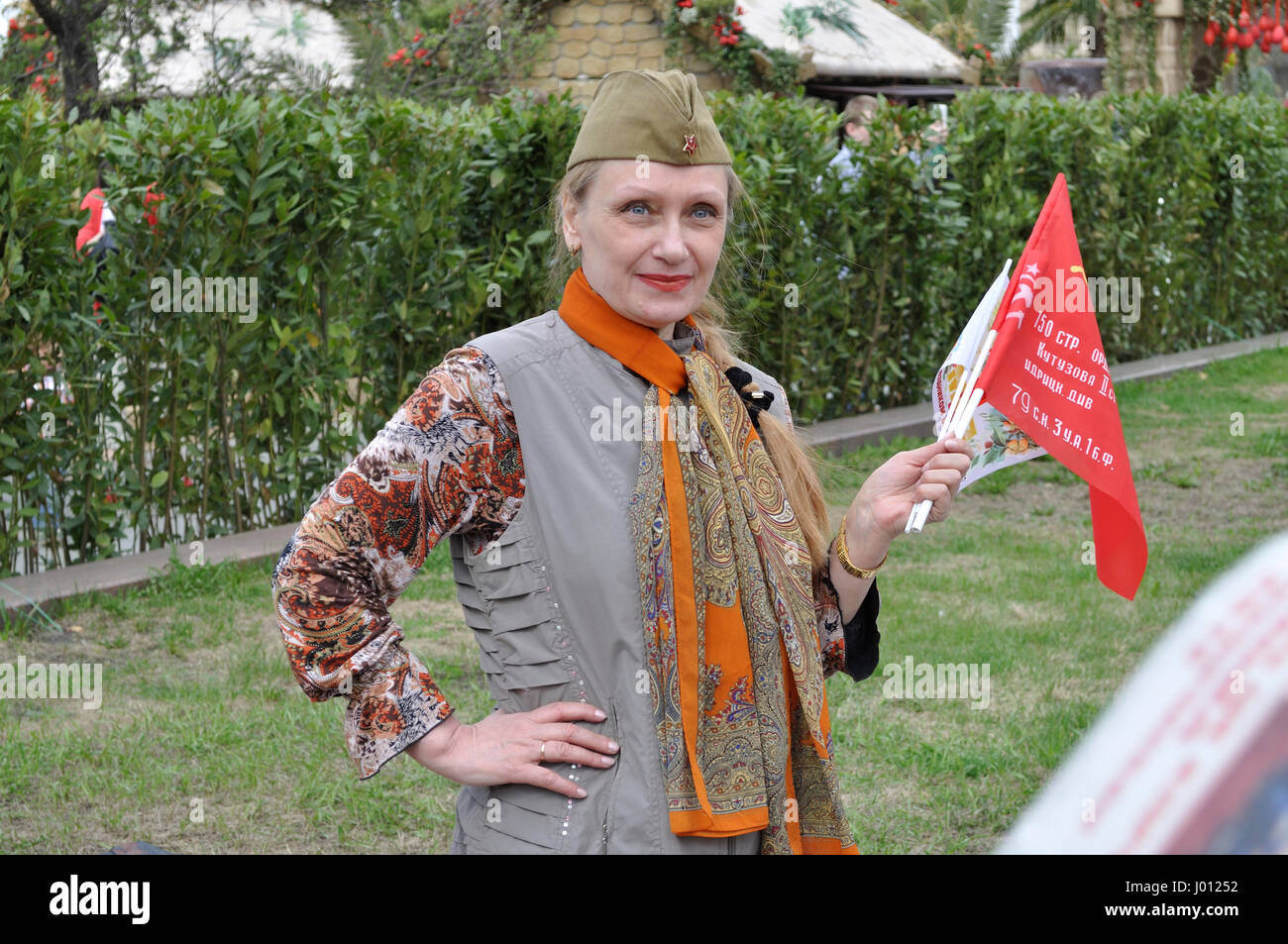 Donna vendita bandiere comunista durante un giorno di primavera e del lavoro. Foto Stock