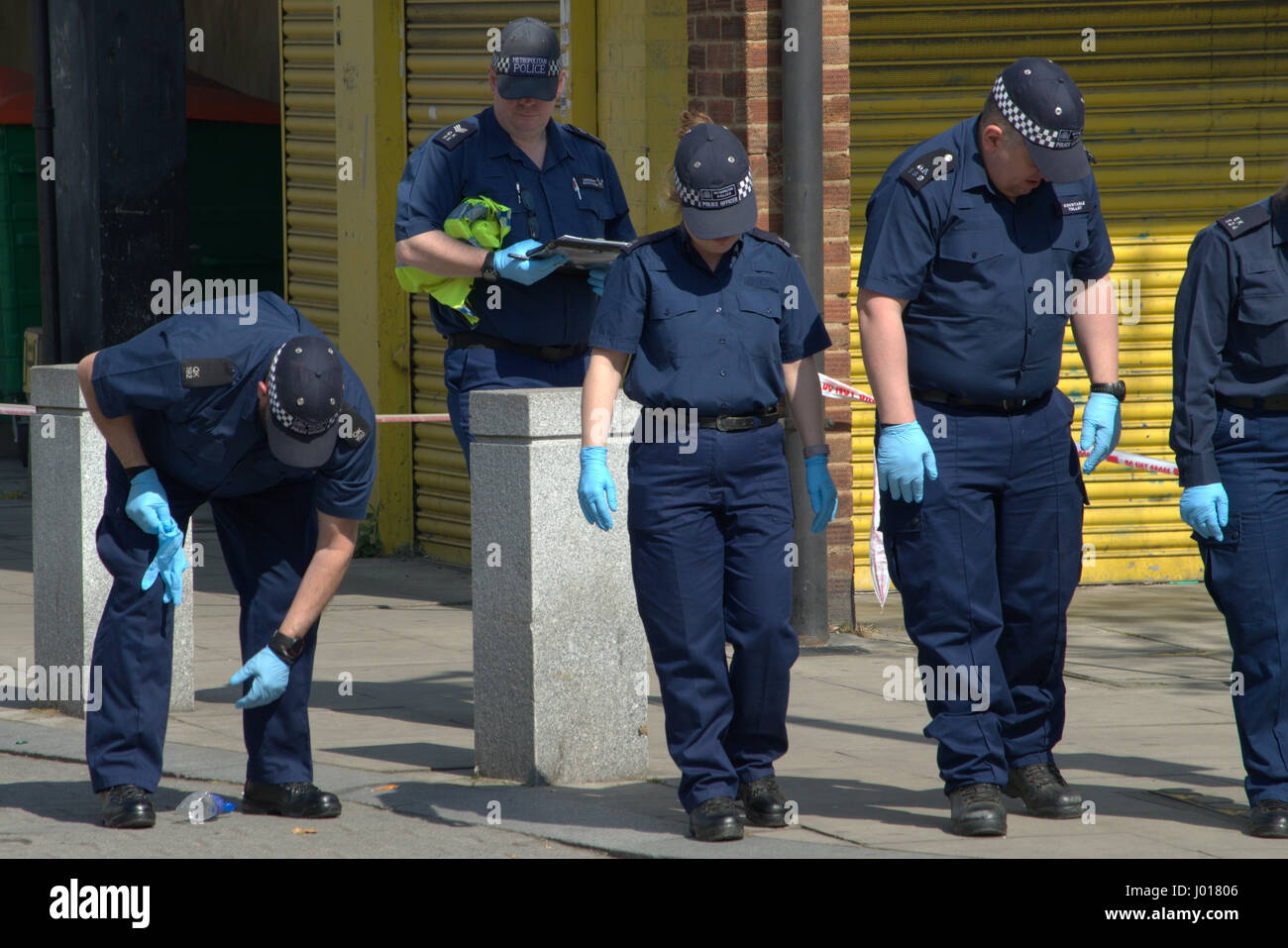 La ricerca di polizia della scena del crimine per prove come parte dell'indagine per omicidio in North Woolwich Londra Foto Stock