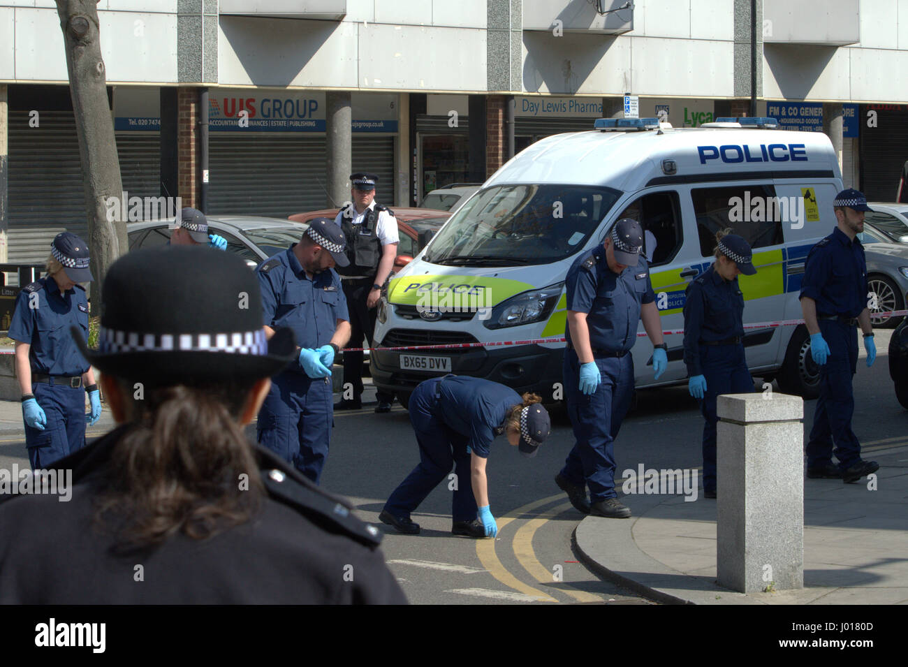 La ricerca di polizia della scena del crimine per prove come parte dell'indagine per omicidio in North Woolwich Londra Foto Stock