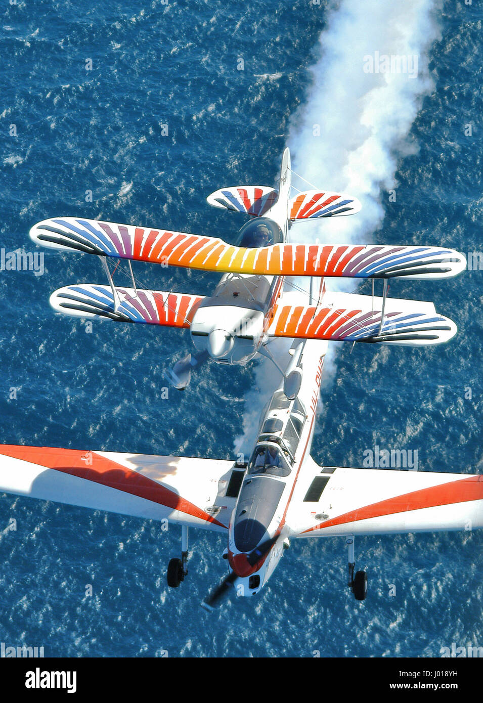 Vista aerea di una formazione di acrobazia aerea in formazione sull'oceano, con il fumo. DH Scoiattolino e Christen Eagle aerei. Foto Stock