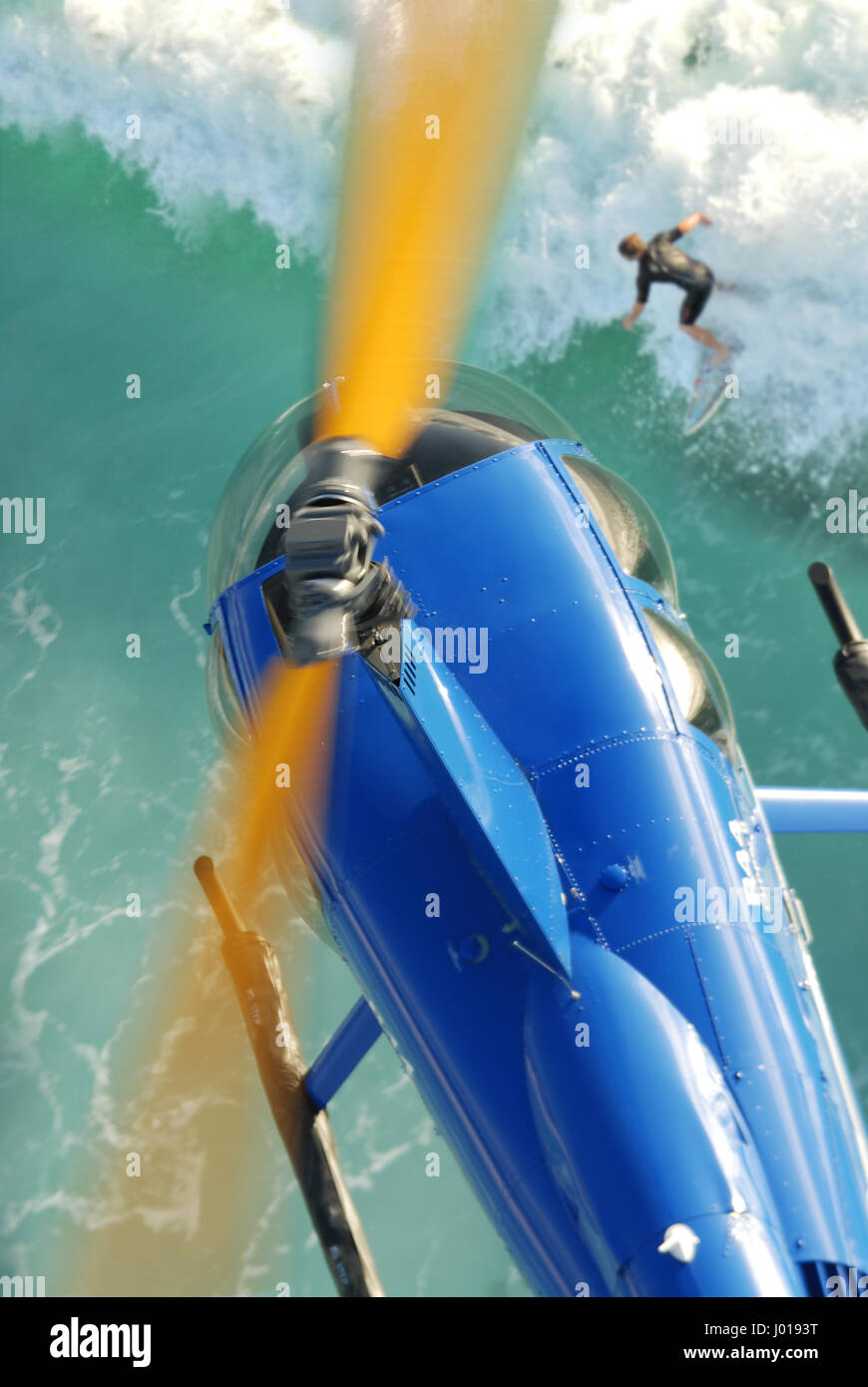 Una veduta aerea di un Robinson R44 Clipper elicottero volando al di sopra di un surfista, Margaret River, Western Australia. Foto Stock