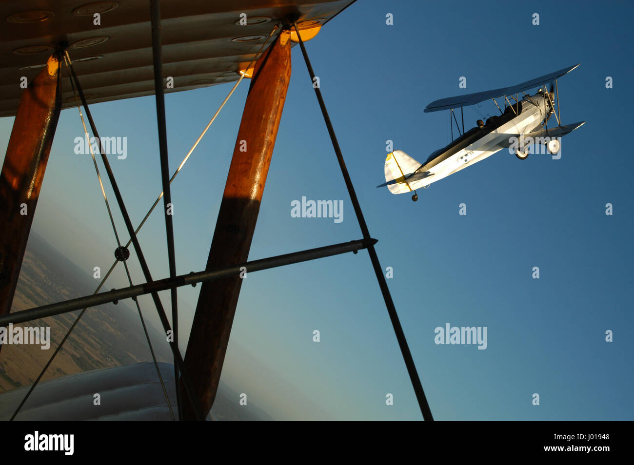 Un 1930 Focke-Wulf FW44 Stieglitz prese da un DH Tiger Moth, entrambi i biplani sono in formazione, vicino alla parte superiore di un loop. Foto Stock