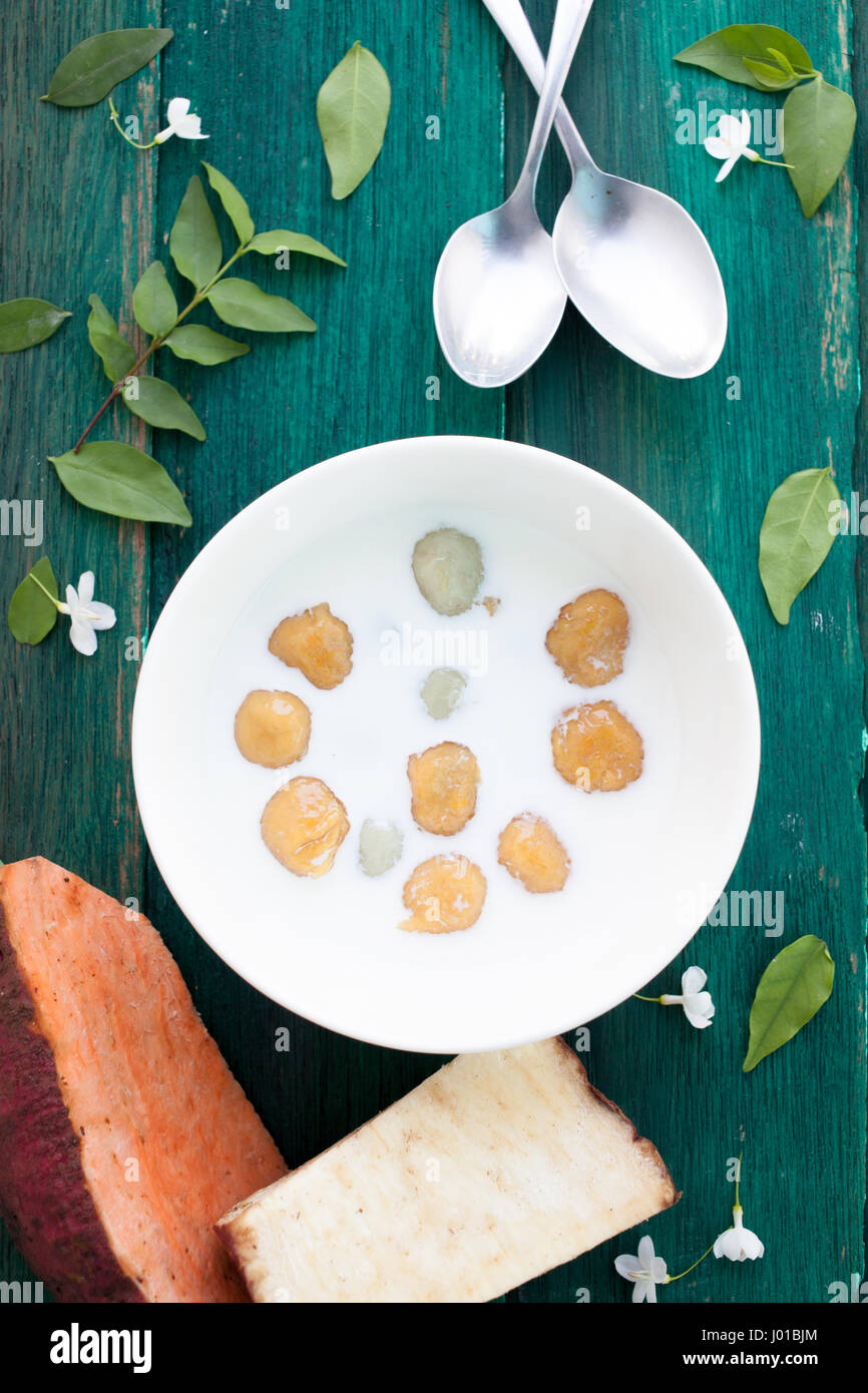 Giapponese di patate dolci gnocco di latte di cocco Thai dessert con piatto laici sullo sfondo di legno Foto Stock