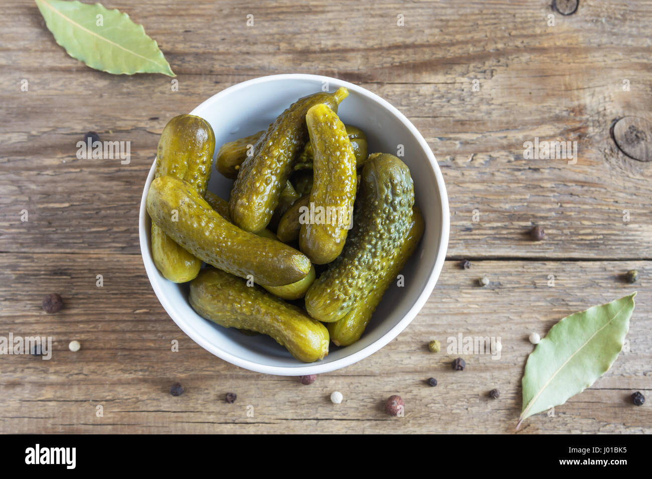 Pickles. Ciotola di cetriolini sottaceto (cetrioli) oltre rustico sfondo di legno vicino. Foto Stock
