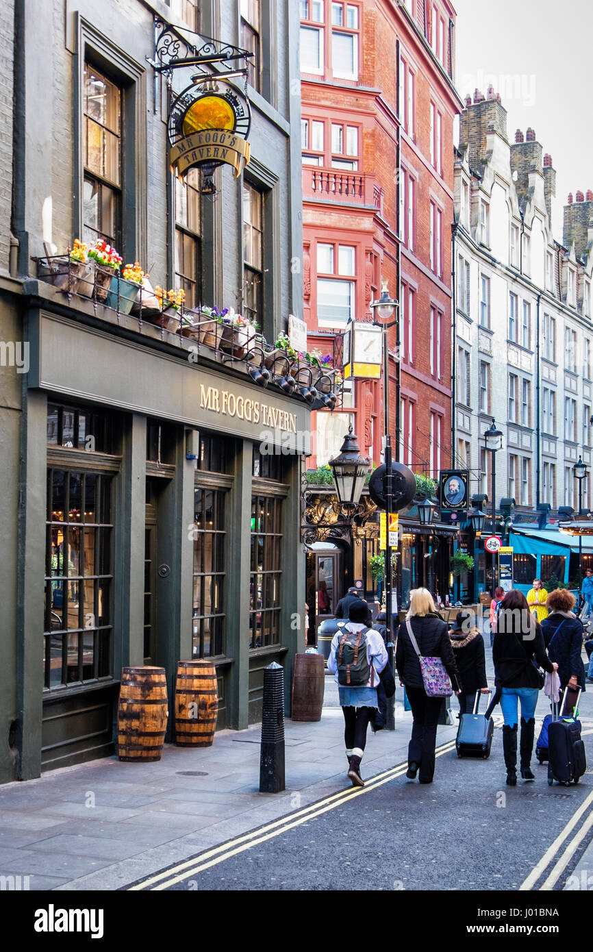 Signor Fogg's Tavern, London, England.tipico pub inglese tradizionale edificio esterno e firmare con i turisti a piedi giù per la strada. In vecchio stile taverna Foto Stock