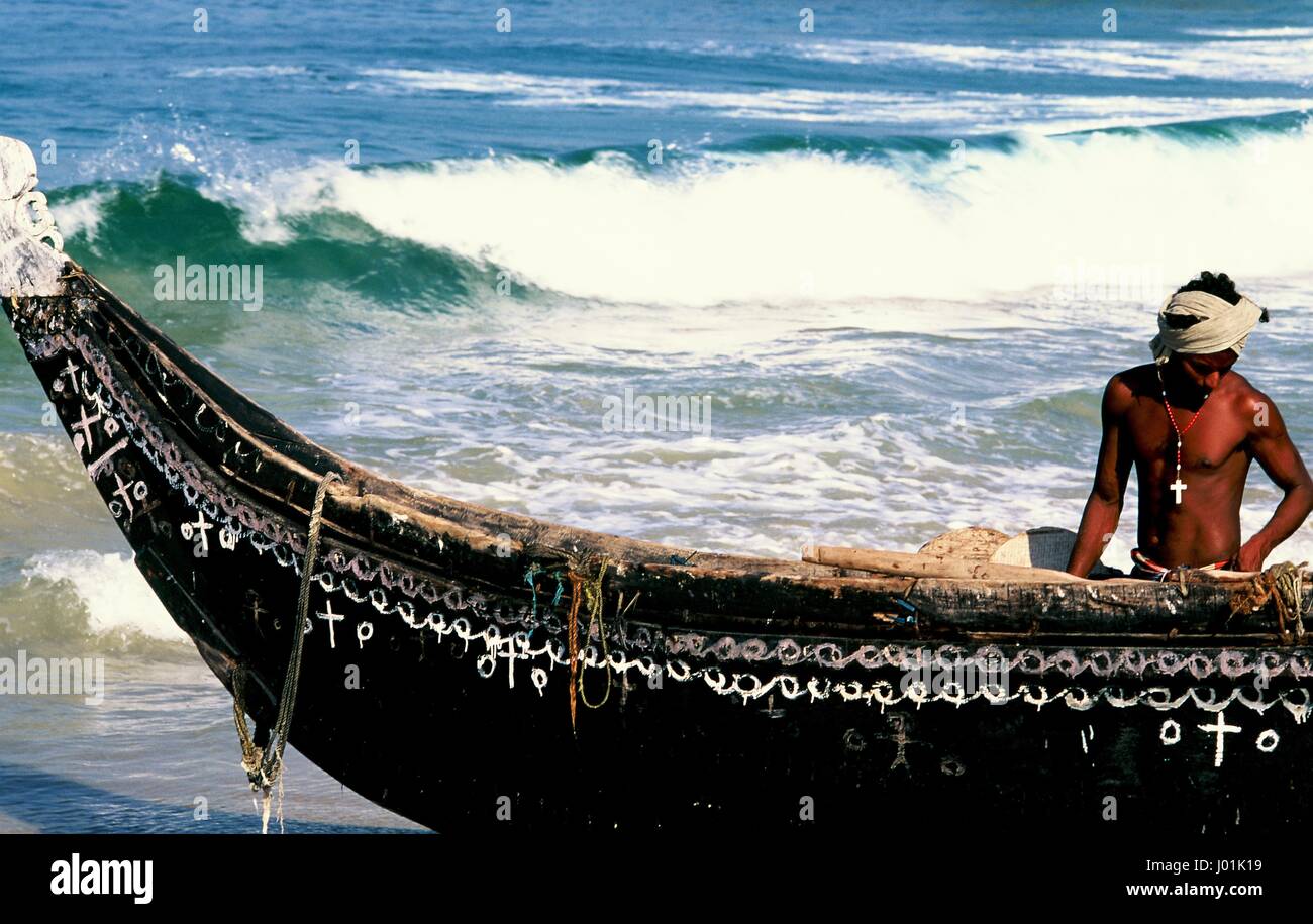 Un pescatore cristiano con la sua barca su Kovalam Beach in Kerela, India. Foto Stock