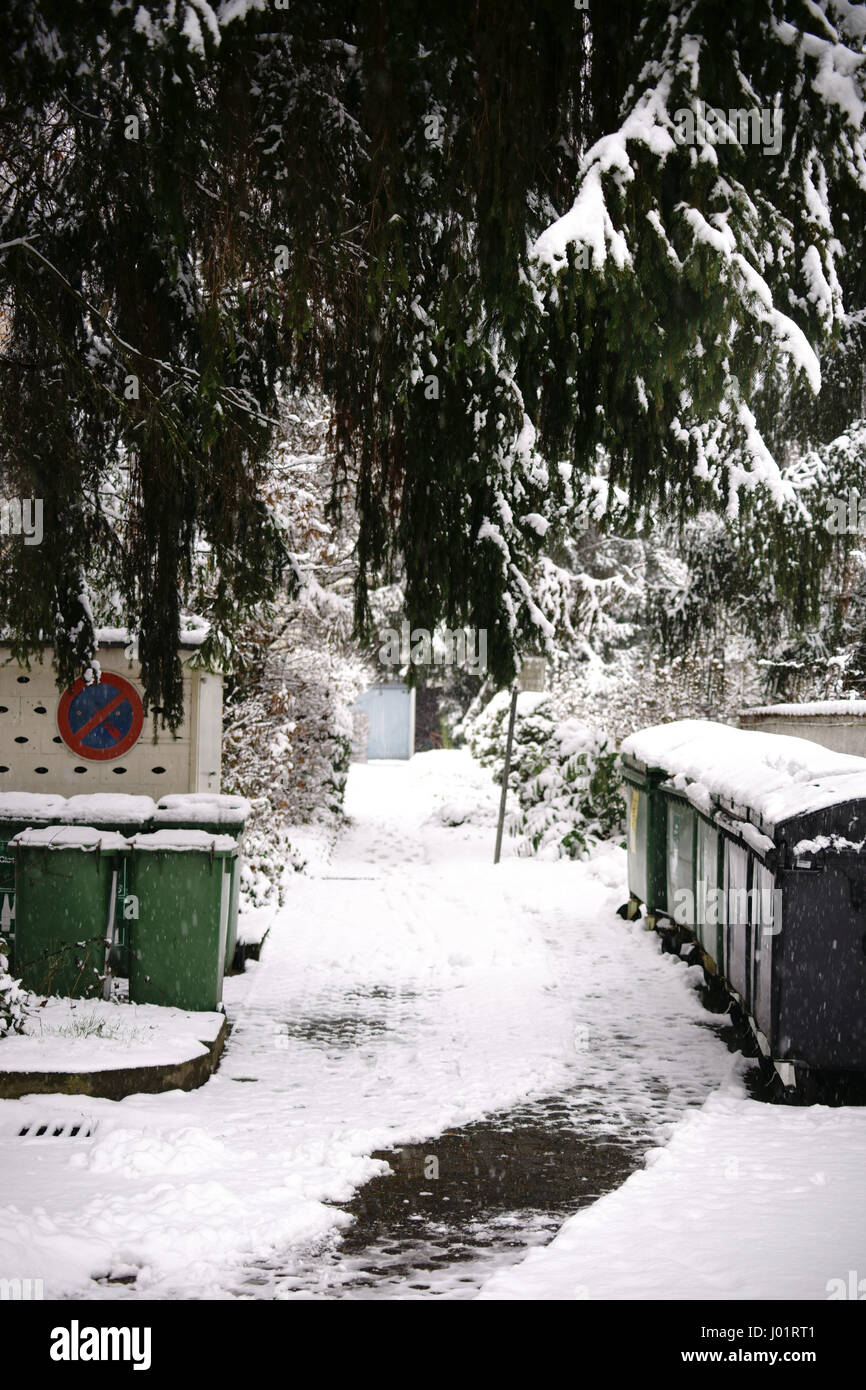 Snowbound Rifiuti di vetro stand contro una casa di storage e la passerella. Foto Stock