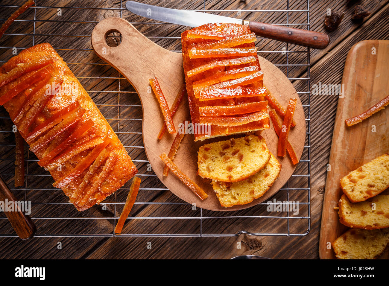 La torta con la scorza d'arancia candita sul tagliere di legno Foto Stock