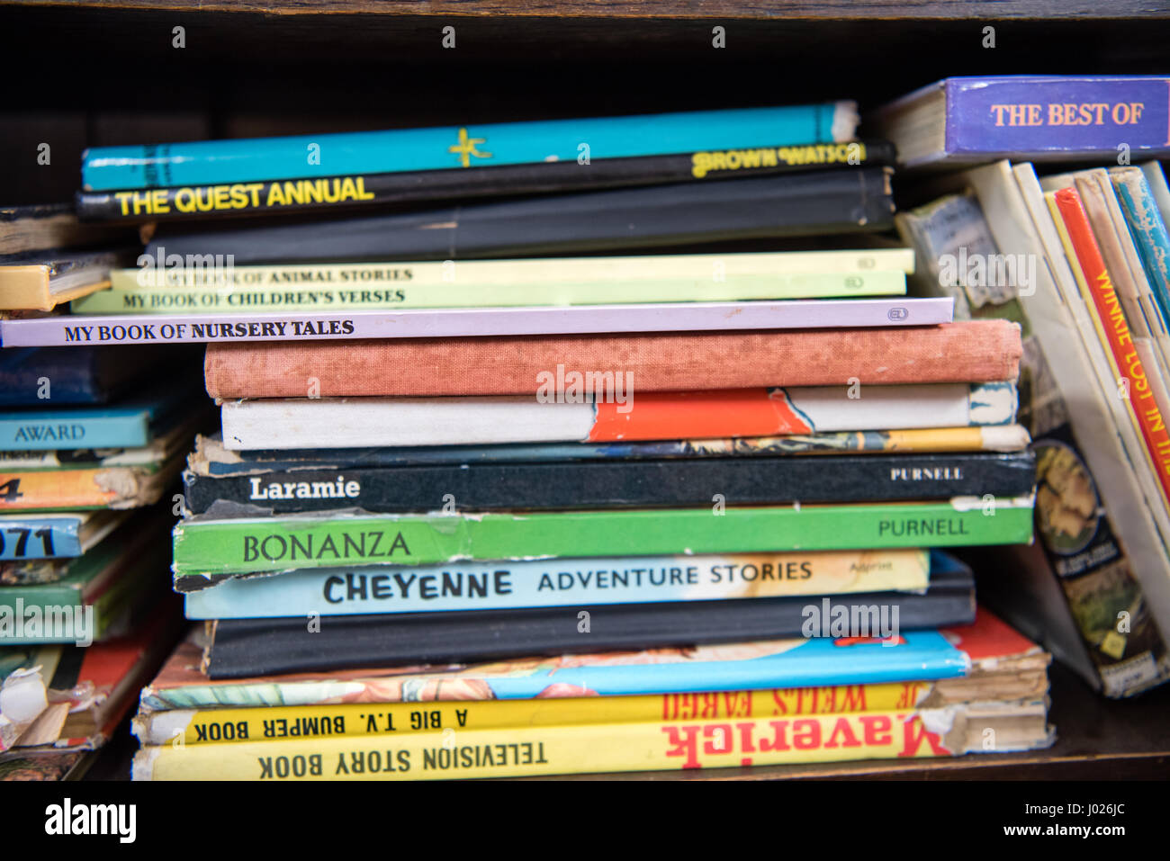 Mucchio disordinato di travagliato anni sessanta e settanta figli di annuari e amati libri impilati in un antico negozio di posta indesiderata Foto Stock
