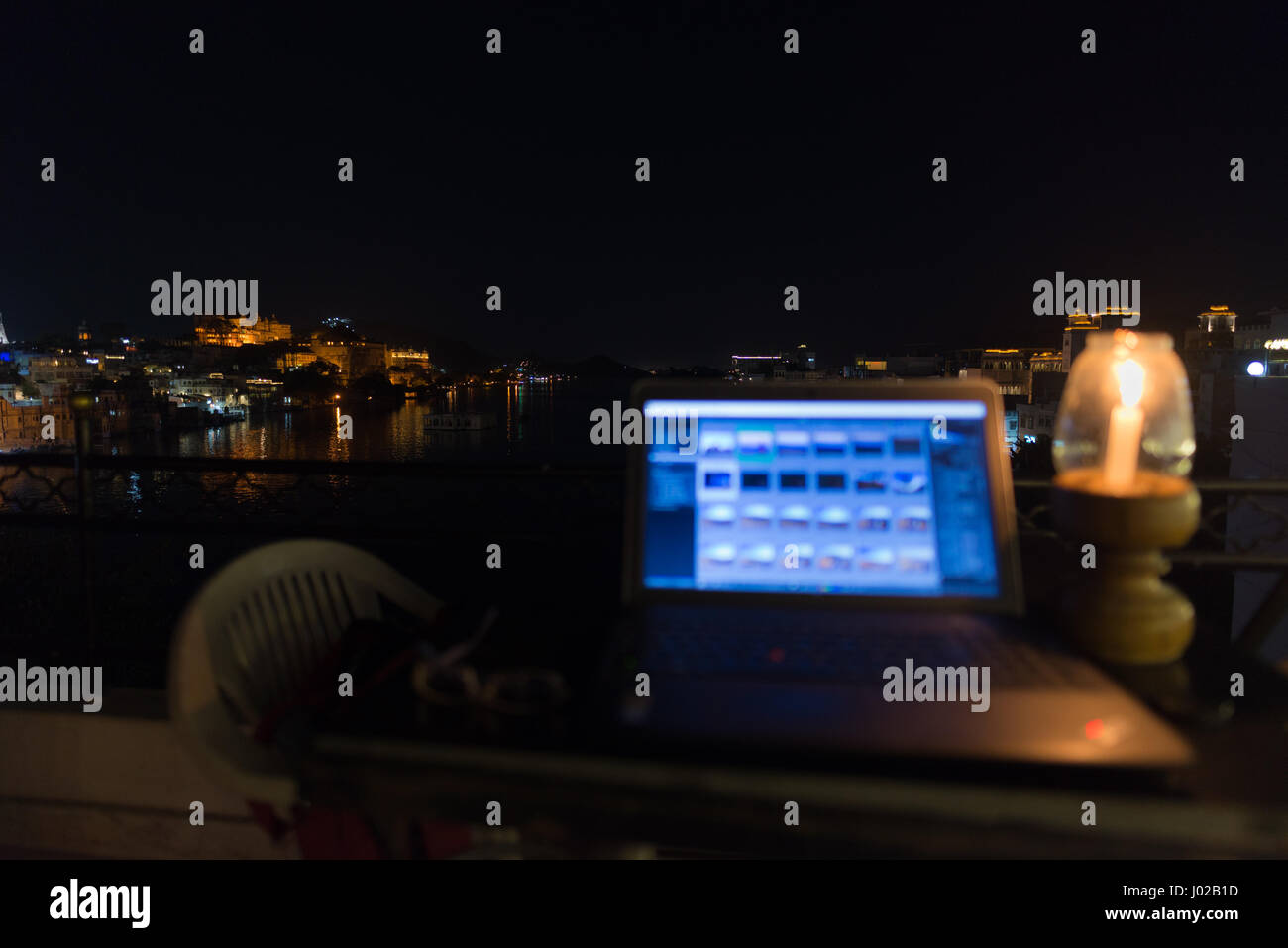 Lavorare mentre si è in viaggio, il concetto di digital nomadi. Sul computer portatile sul tavolo con scenic vista panoramica di notte. Focus su sfondo. Foto Stock