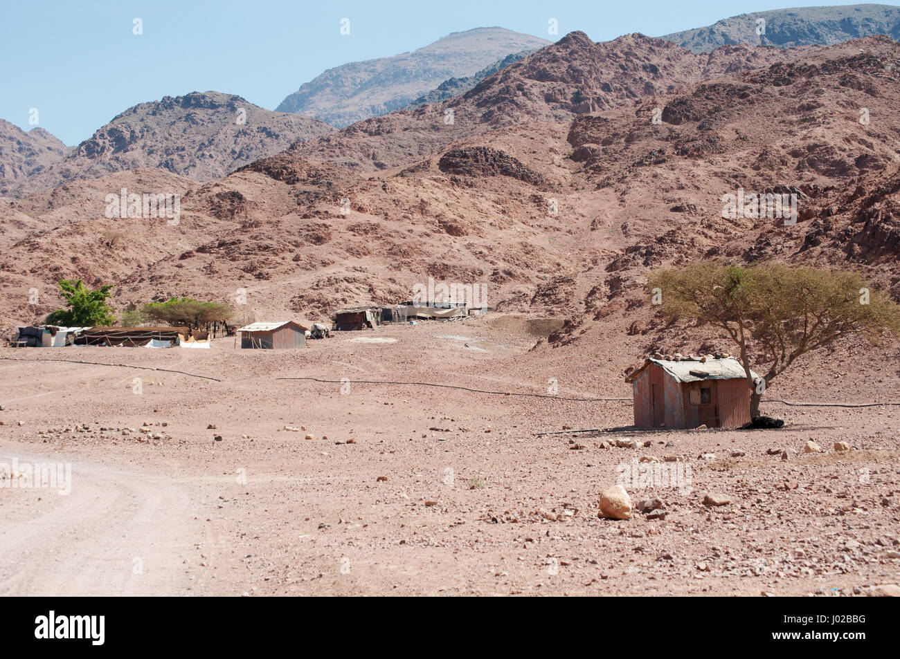 Giordania: edifici nel paesaggio del deserto di Dana Riserva della Biosfera, un'area protetta che è un crogiolo di specie provenienti da Europa, Africa e Asia Foto Stock