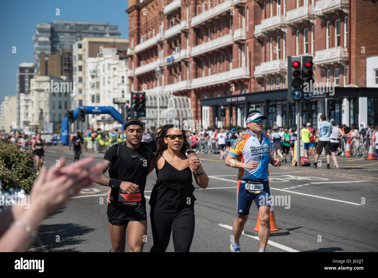 Brighton, Regno Unito. 09Apr, 2017. Donna Uomo aiuta a terminare la gara di concorrenza a Brighton Marathon. Credito: Marius Comanescu/Alamy Live News Foto Stock