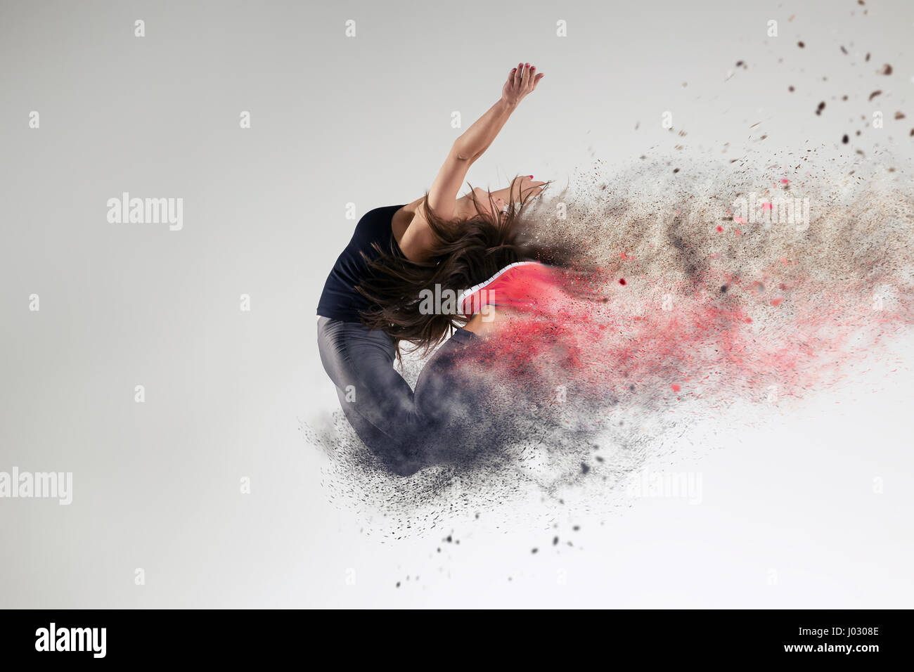 La donna nel salto in studio e effetto di disintegrazione Foto Stock